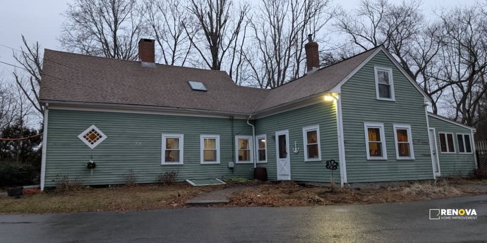Completed brown asphalt-shingle roof on a green home