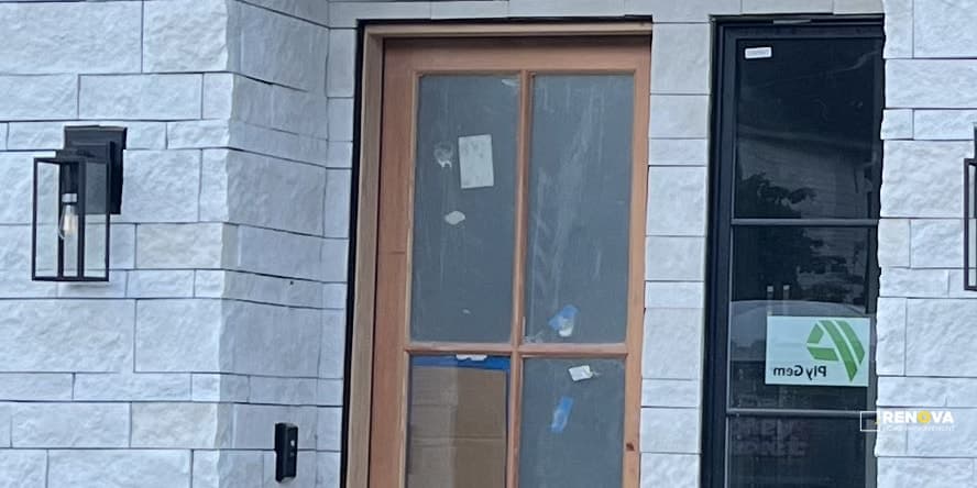 Wood entry door installed in a dark exterior wall