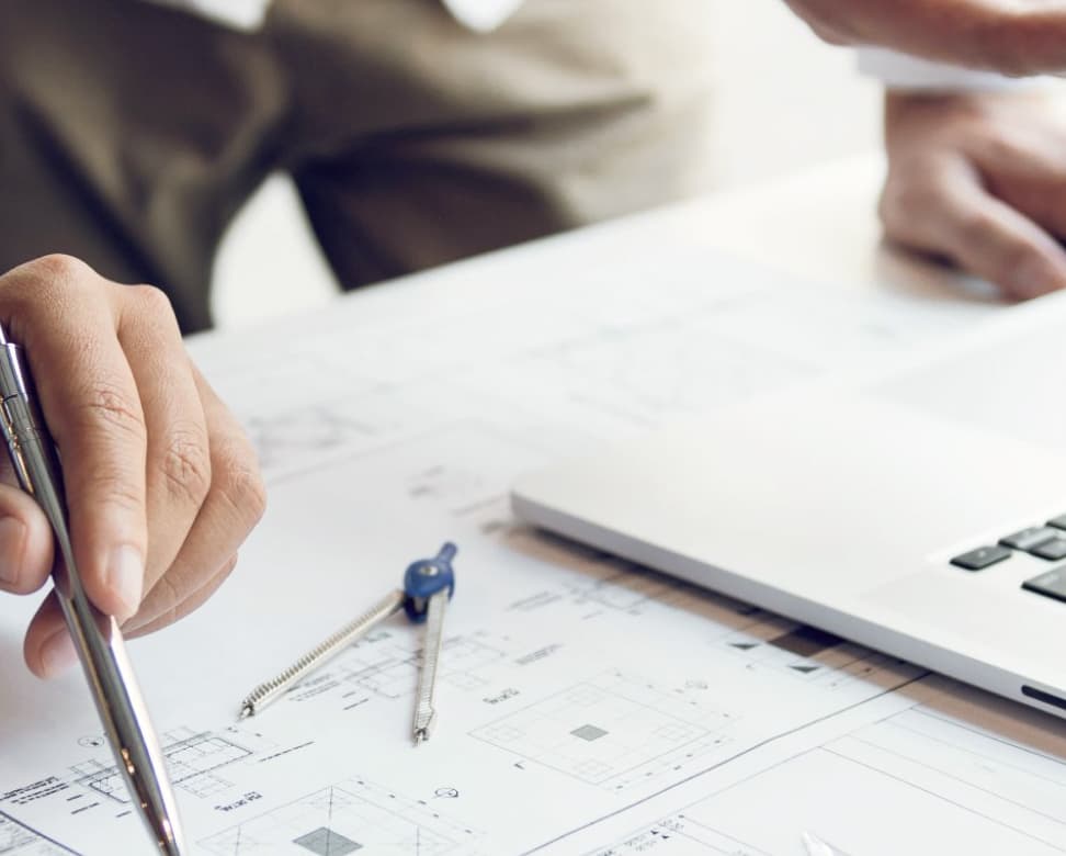 Architect reviewing residential plans with drafting tools